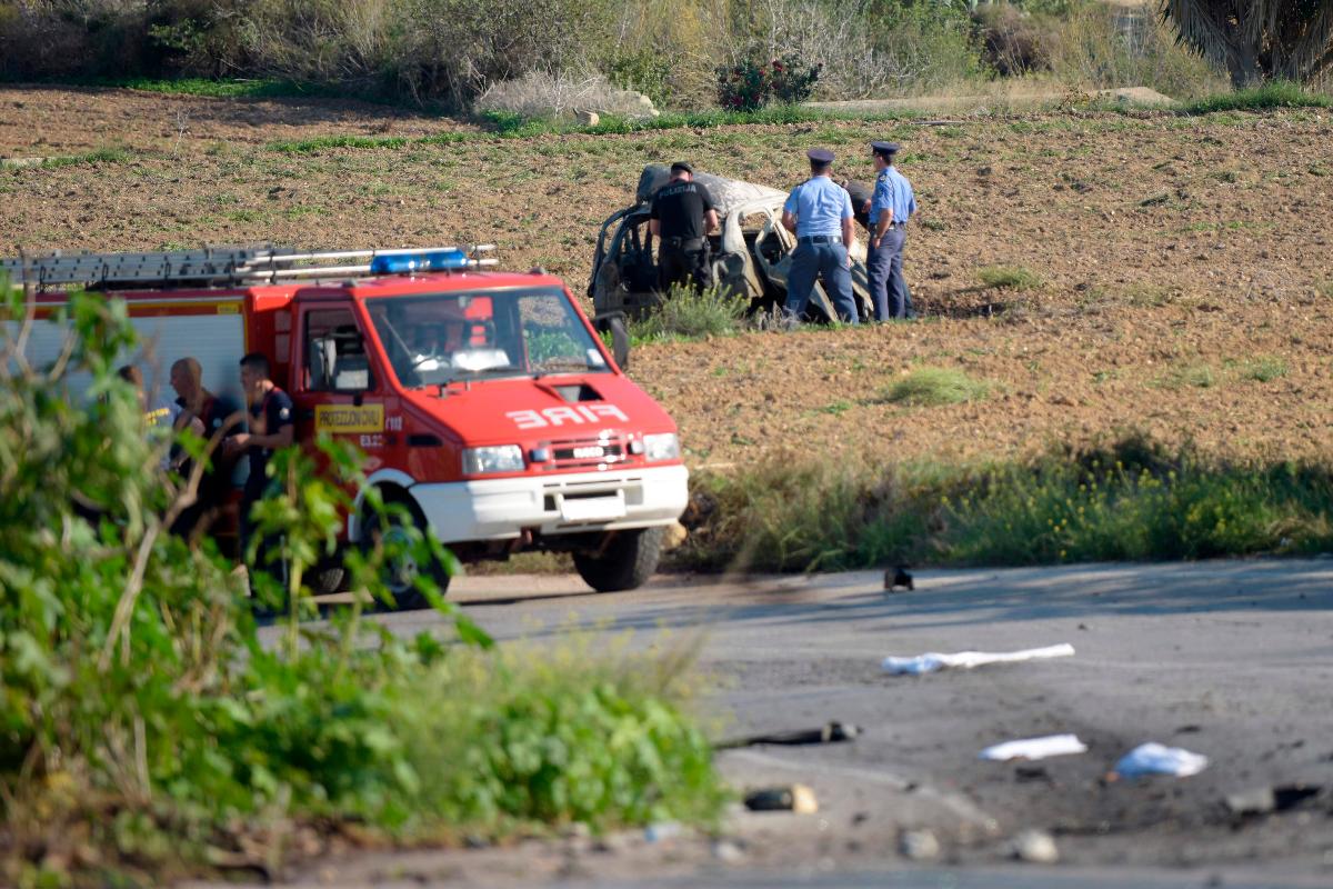 A polícia durante investigação dos destroços do carro-bomba que acredita-se ter matado a jornalista Daphne Caruana Galizia perto de sua casa em Bidnija, Malta | STR/AFP
