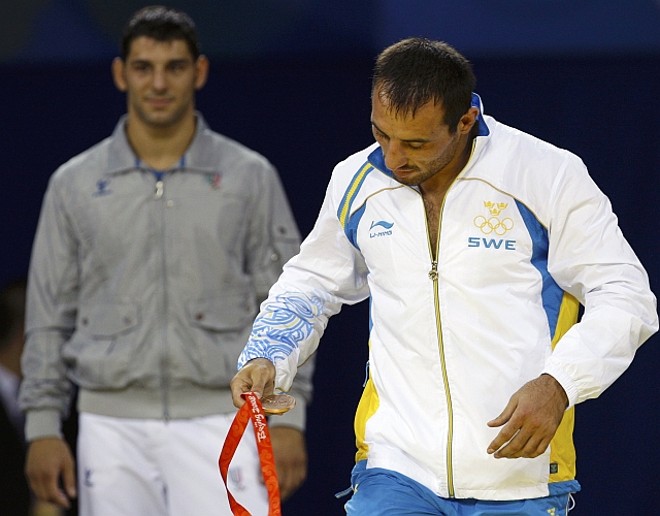 Ara Abrahamian retira a medalha de bronze do pescoço |