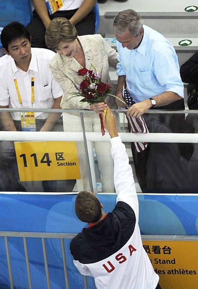 Antes de entregar as flores recebidas pelos medalhistas à primeira-dama Laura Bush. | 