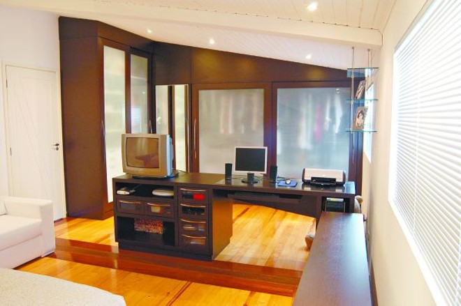 No outro lado, o espaço para o trabalho e o closet com portas de correr serigrafadas |