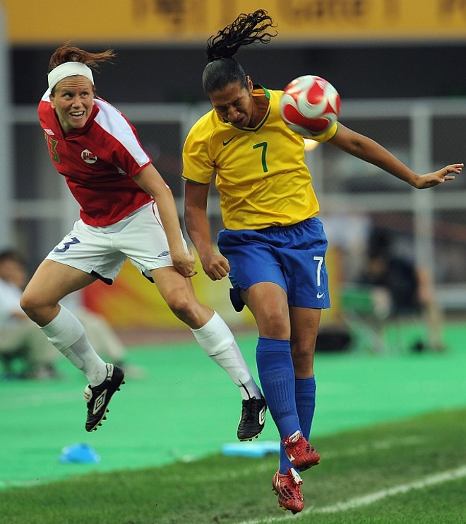 Daniela Alves, autora do primeiro gol brasileiro, cabeceia a bola acompanhada de Folstad | 