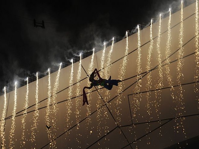 Bailarino voa no centro do estádio, durante festa de abertura dos Jogos Olímpicos |