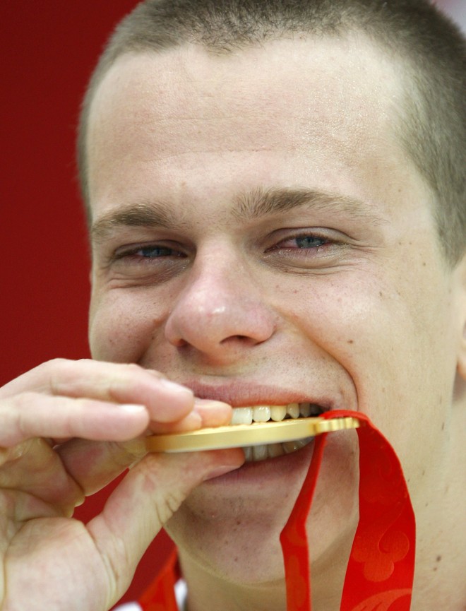 César Cielo morde medalha de ouro. Ele foi o primeiro nadador brasileiro a conquistar o ouro olímpico em Pequim |