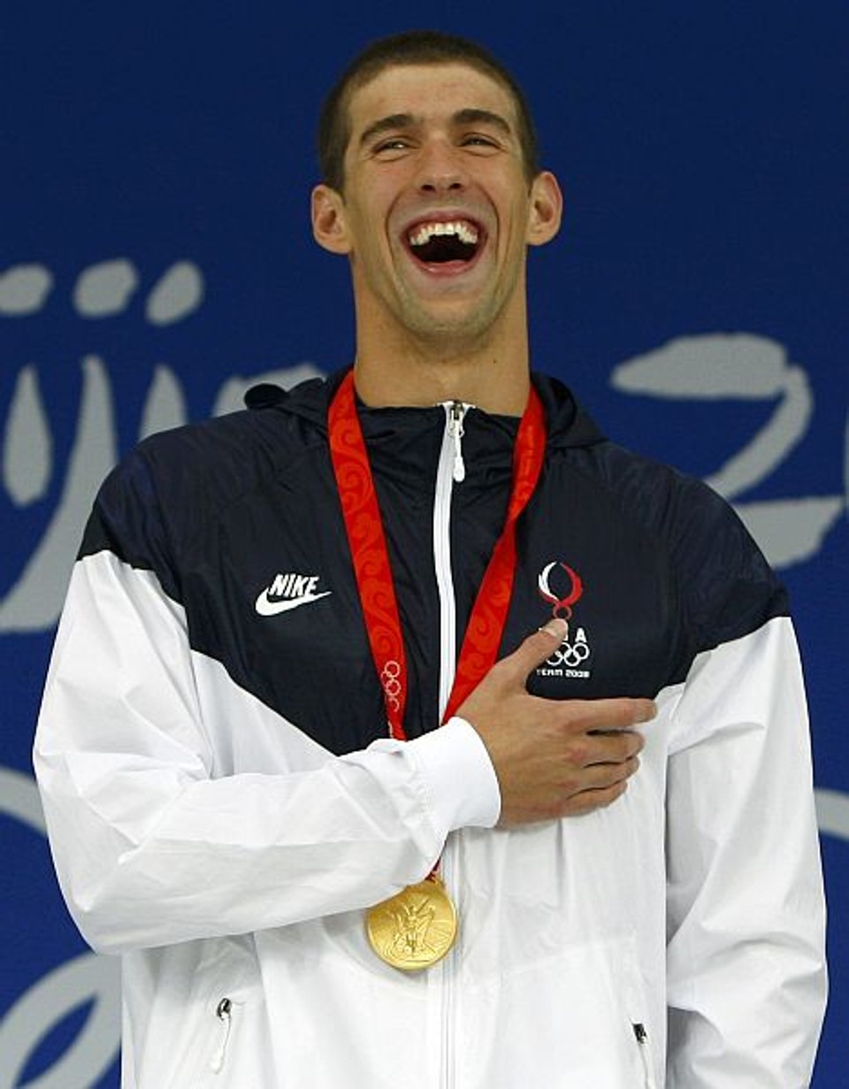 Michael Phelps comemora o primeiro ouro em Pequim no pódio... | David Gray/ Reuters
