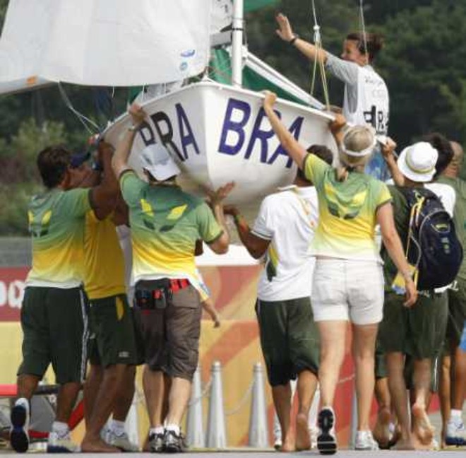 Brasileiras Fernanda Olivera e Isabel Swan são carregadas dentro do barco por membros da delegação brasileira depois de conquistaram a medalha de bronze da classe 470 |