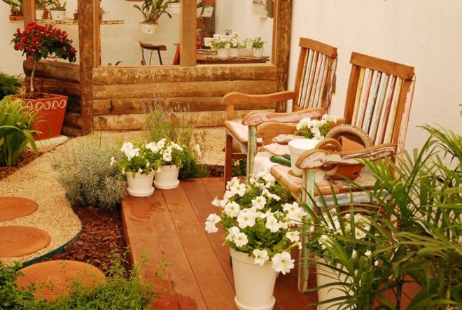 Proteção: Criado pela paisagista Tamara França, a Estufa e Jardim (ambiente que protege as plantas da variação climática) tem deck externo com bancos de madeira, chão de pedriscos (que mantém a umidade local) e vasos com primaveras |