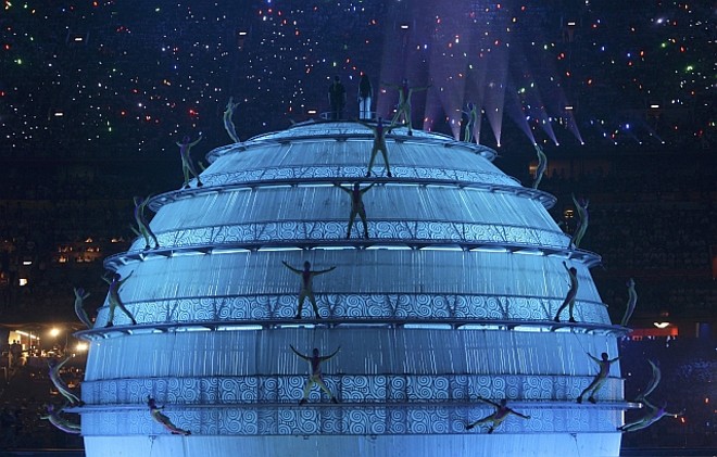 Acrobatas presos por cabos fazem performances no globo no centro do Estádio Nacional |