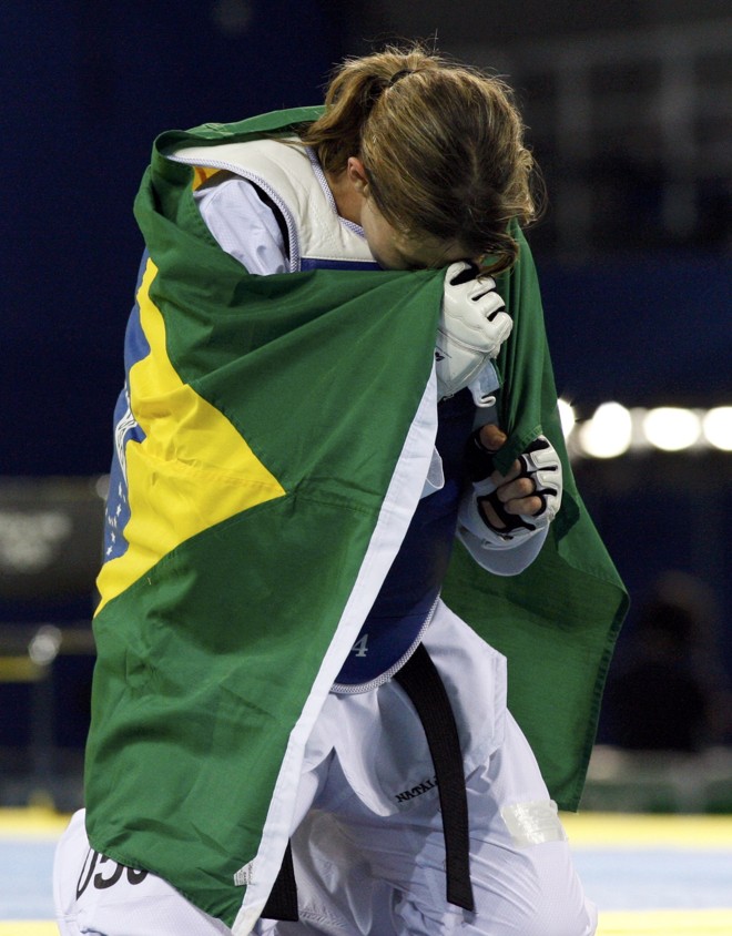 Natália Falavignia chora enrolada na bandeira brasileira, após a conquista do bronze |