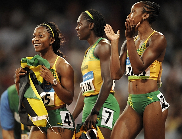 Shelly-Ann Frasier (à esquerda) comemora o ouro nos 100m rasos ao lado das compatriotas Kerron Stewart e Sherone Simpson - empatadas com a prata - num pódio todo jamaicano | OLIVIER MORIN/AFP