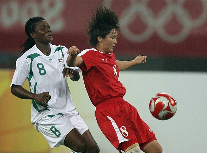 Hui Kil Son da Coréia do Norte disputa o lance com a nigeriana Ifeanyi Chiejine |