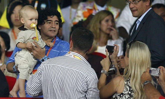 Diego Armando Maradona assiste o jogo segurando uma criança; Ídolo argentino vibrou com a vitória argentina e os dois gols de seu genro Sergio Aguero |