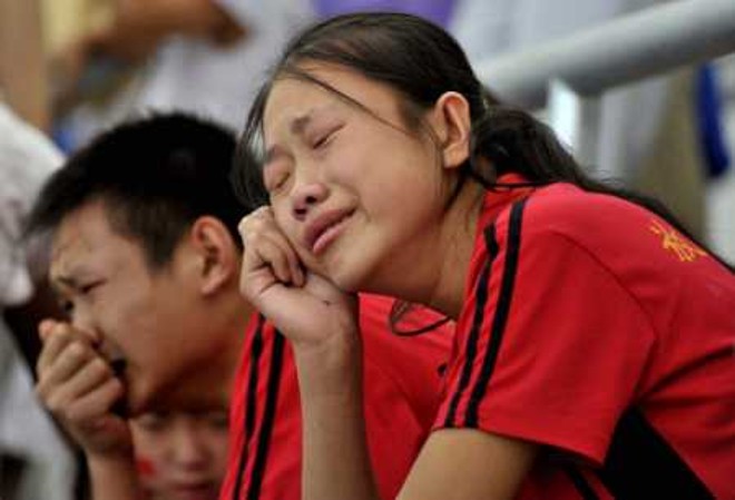 Torcedores chineses choram após a desistência de Liu Xiang na prova dos 110m com barreira dos Jogos de Pequim |