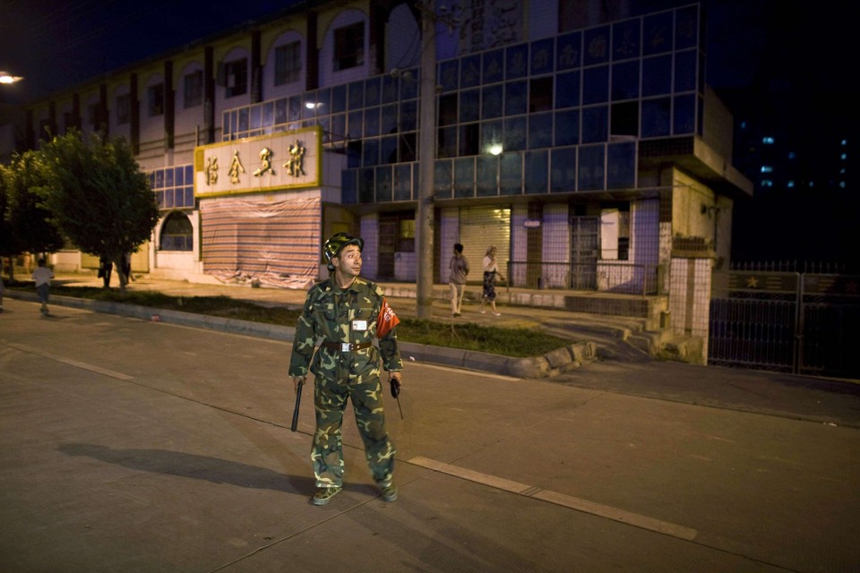 Membro da força de segurança da China, monitora o cenário que foi palco de um ataque bomba: explosivos foram jogados contra policiais que realizavam sua corrida matinal | Nir Elias / Reuters