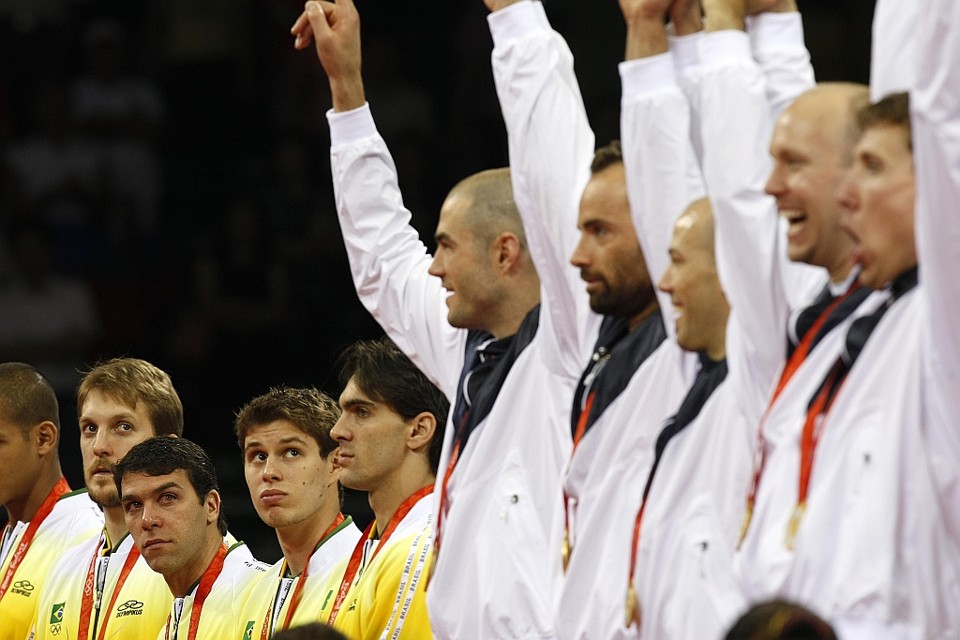 Os jogadores da seleção brasileira de vôlei observam a festa norte-americana no pódio: Giba (o último brasileiro na imagem) diz que precisará de tempo para digerir a derrota em Pequim. | Jonathan Campos, enviado especial/ Gazeta do Povo