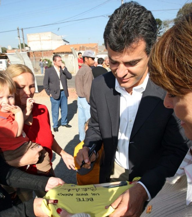 Distribuindo autógrafos em bairro de Curitiba: busca de popularidade. |