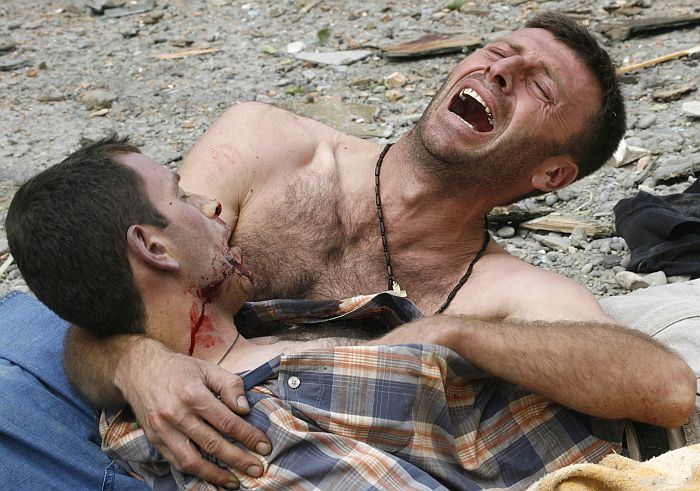 Homem chora sobre o corpo de seu irmão, na cidade de Gori, bombardeada pelos russos | David Mdzinarishvili/Reuters