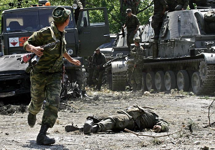 Soldado russo passa correndo próximo ao corpo de um soldado da Geórgia. Os combates continuam | Dimitri Kostyukov/AFP