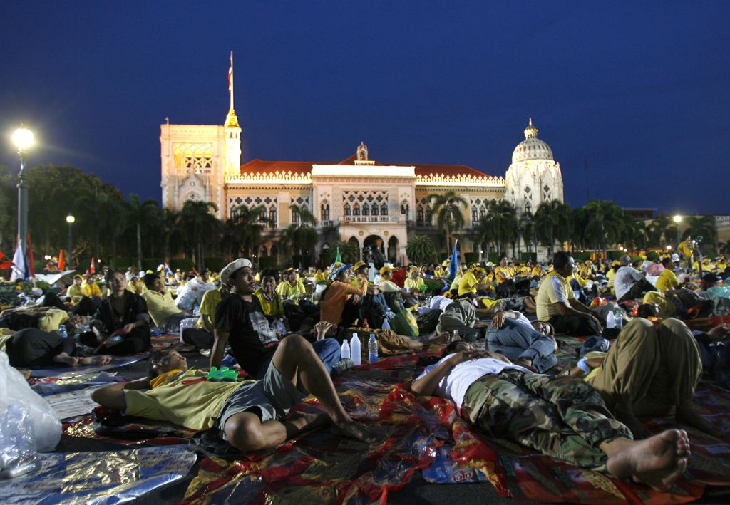 Milhares de manifestantes deitados no gramado serão convencidos pelas forças de segurança a deixarem o local | Chaiwat Subprasom / Reuters