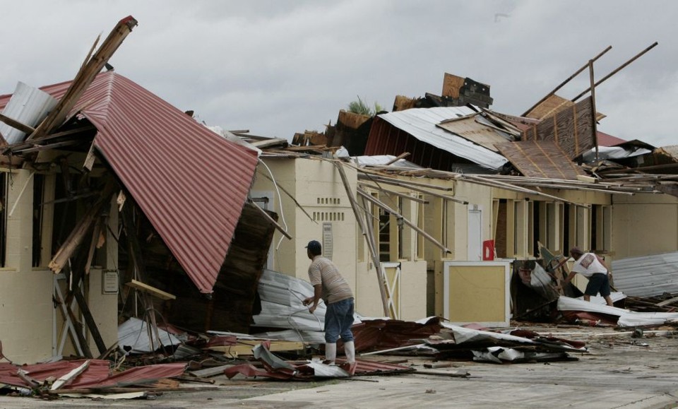 Homens trabalham para limpar estragos provocados em residências na Flórida, durante passagem da tempestade Fay | Reuters