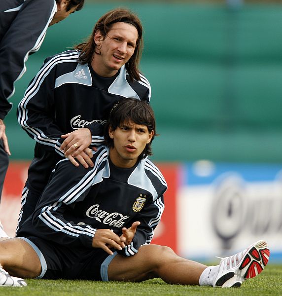 Messi (alongando com Agüero) jogou domingo pelo Barcelona e ontem já estava treinando com a seleção argentina. | Enrique Macarian/Reuters