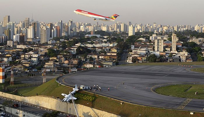 O avião tentava decolar mas derrapou, saiu da pista e ficou "pendurado" em um muro | Paulo Whitaker/Reuters