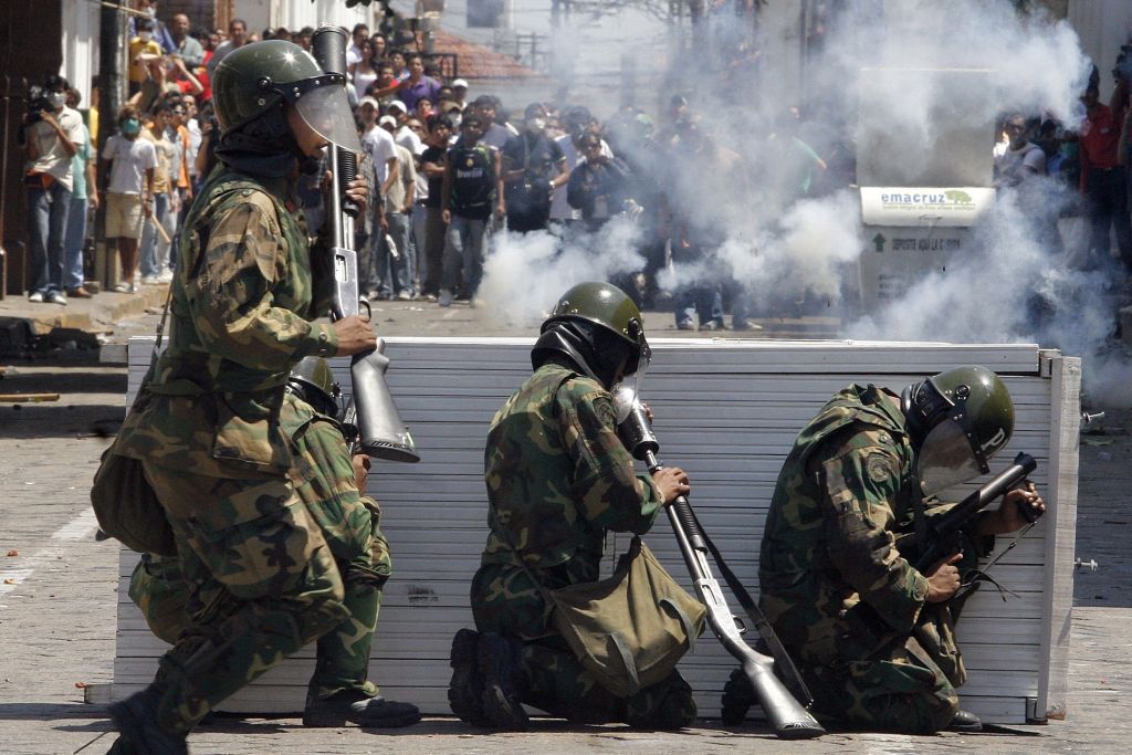 Radicais são contidos por policiais após expulsarem voluntários e funcionários cubanos e venezuelanos da região de Santa Cruz, na fronteira com o Brasil | Carlos Hugo Vaca / Reuters