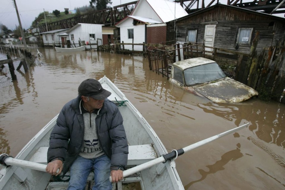 Morador vistoria região com seu barco no sul do Chile, após fortes chuvas atingirem local | Victor Ruiz Caballero / Reuters