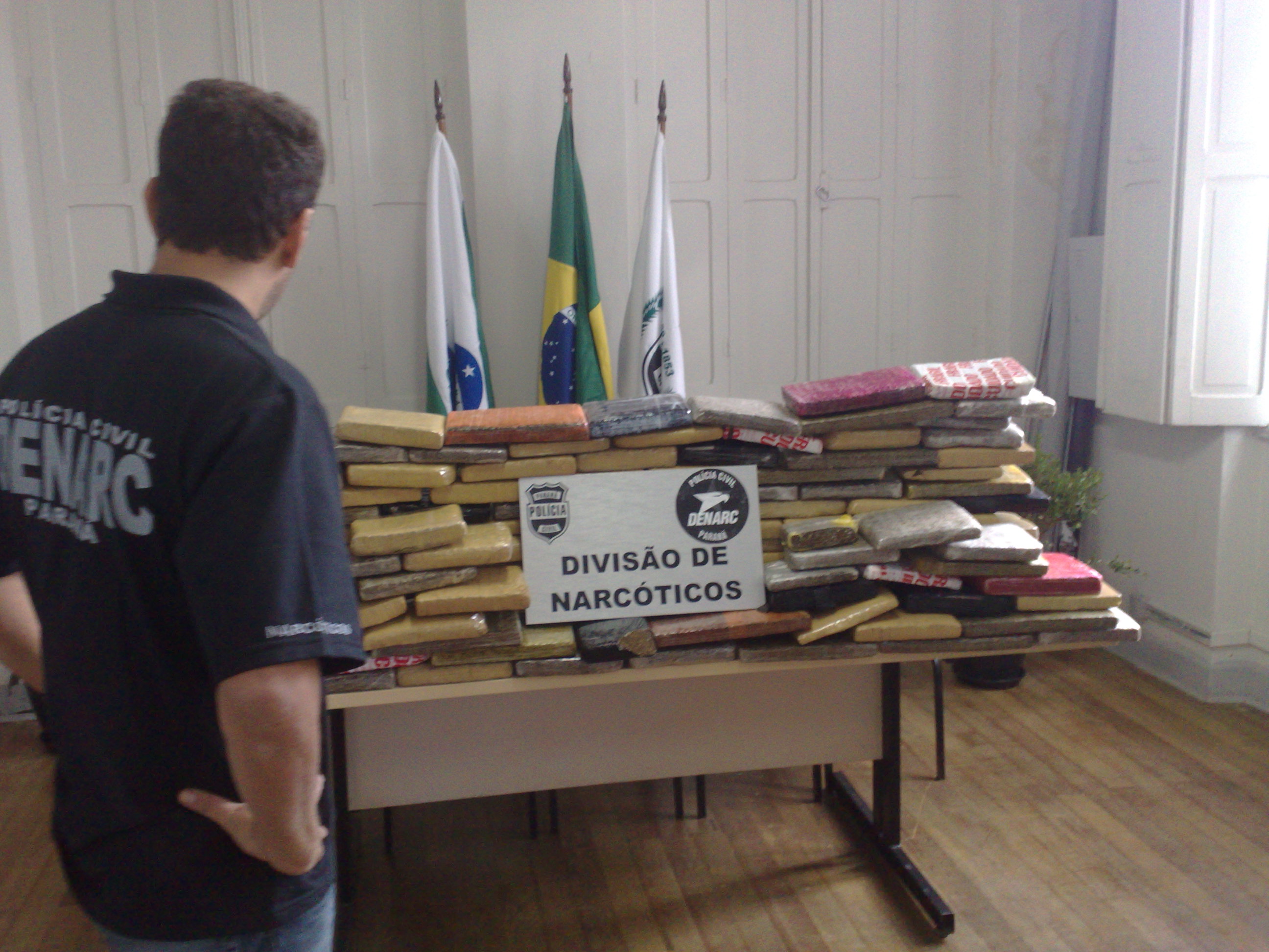 O delegado-chefe da Denarc de Curitiba, Rodrigo Brown de Oliveira, diante da maconha apreendida | João Varella / Gazeta do Povo