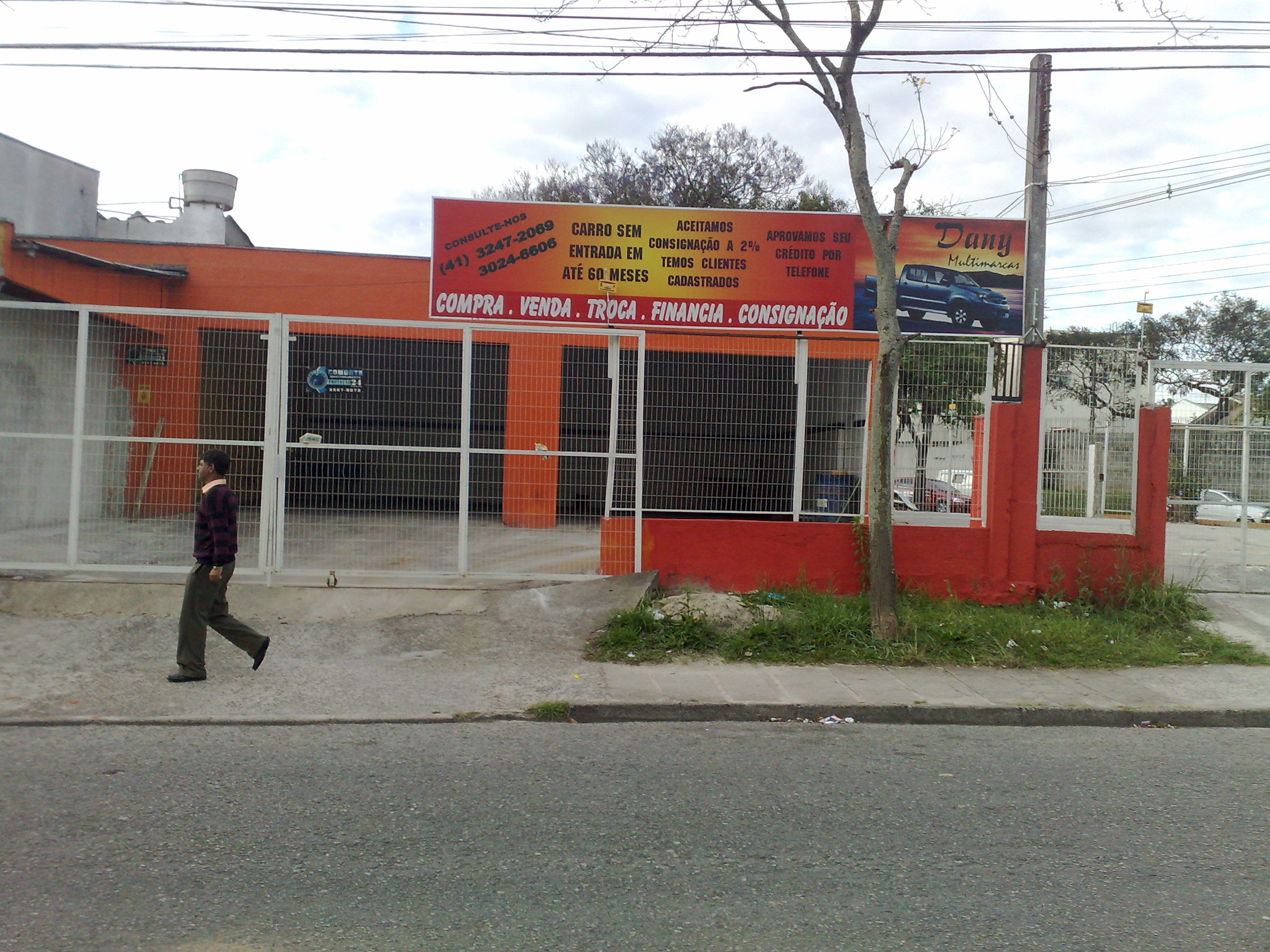 Transeunte passa em frente da loja Dany Multimarcas, que teve os carros apreendidos | João Varella / Gazeta do Povo
