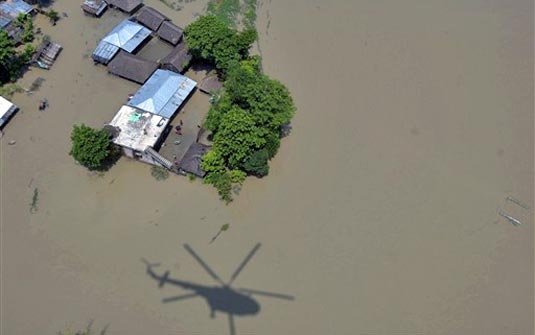 Helicóptero da Força Aérea sobrevoa regiões inundadas à procura de pessoas ilhadas | AFP