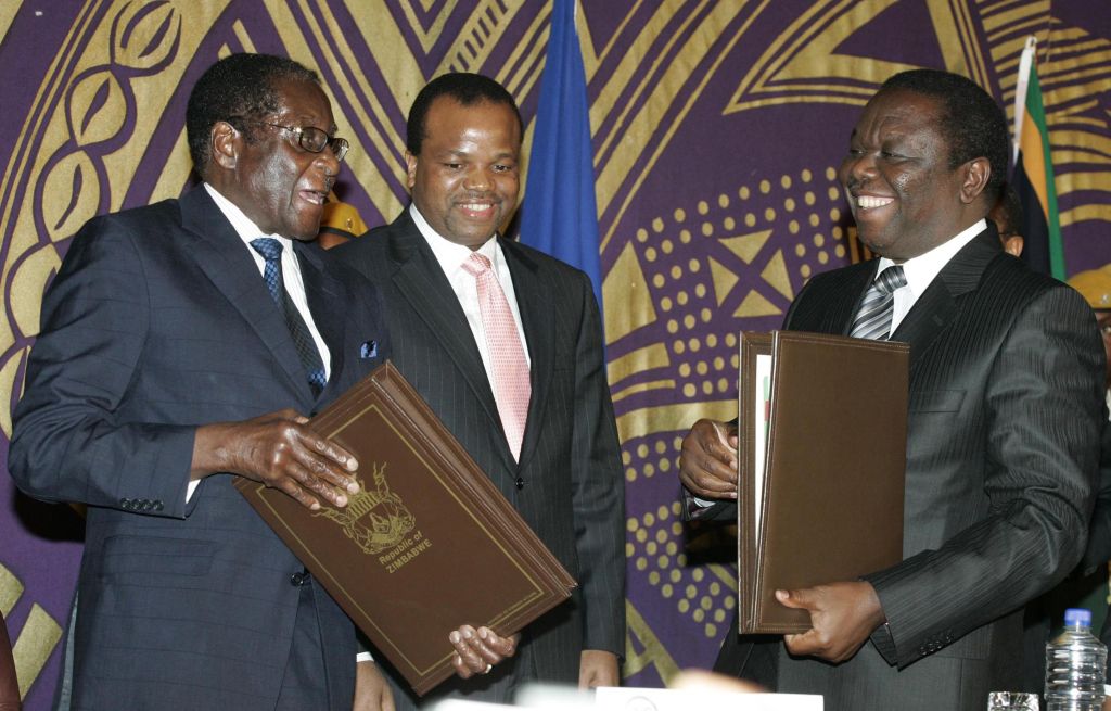 Mugabe (esq.) e Tsvangirai (dir.) assinam acordo que sela três meses de negociações frustradas | Philimon Bulawayo / Reuters