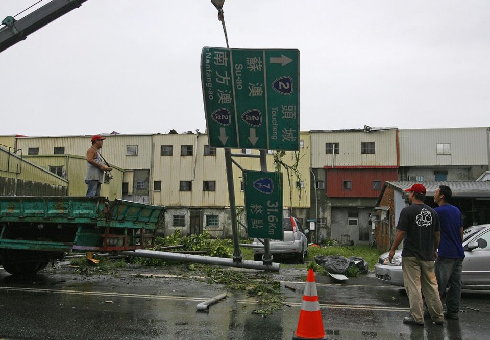 Funcionários da ilha tiveram dificuldades para retirar galhos de árvores e placas caídas nas ruas: tufão provocou chuvas e ventos fortes | Nicky Loh / Reuters