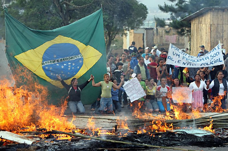 Mulheres e crianças ficaram à frente das barreiras, para tentar impedir a entrada dos policiais no terreno | Albari Rosa/Gazeta do Povo