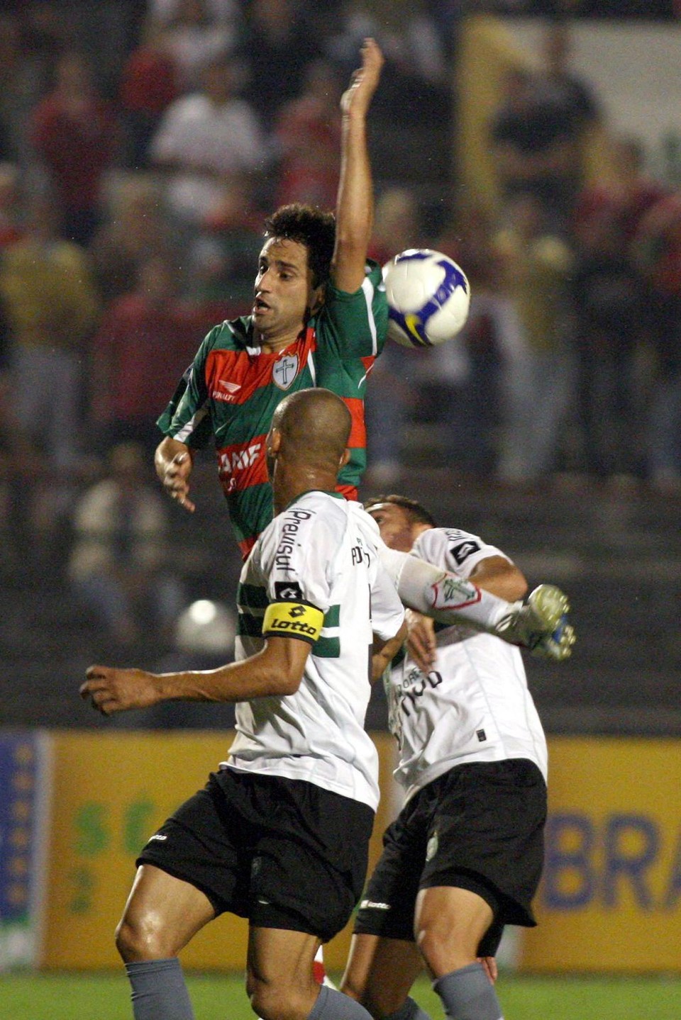 Jonas, da Lusa, disputa jogada com Maurício e Mancha. Atleta da Portuguesa perdeu gol feito e ainda se irritou com a substituição | Ricardo Matsukawa/ Futura Press
