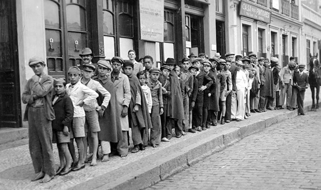 Pequenos vendedores esperando a saída do jornal, em 1938 | 