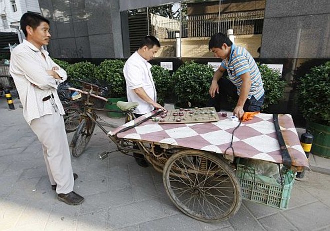 Espécie de carroça serve de mesa para um jogo |
