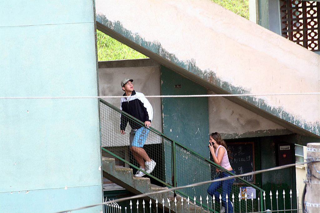 Um irmão do seqüestrador e Nayara, a jovem que havia sido libertada, sobem as escadas para entrar no apartamento | Ale Vianna/Futurapress