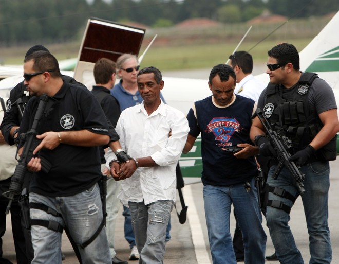 Jair Corrêa (de camisa branca), acusado de ser o mentor da chacina em Guaíra, desembarcou no Aeroporto Bacacheri, Curitiba, com forte escolta policial | Albari Rosa / Gazeta do Povo