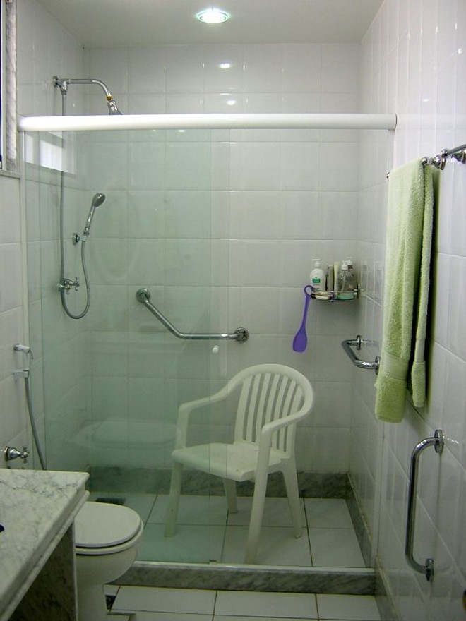 Banheiro com barras de apoio e cadeira para auxiliar no banho | 