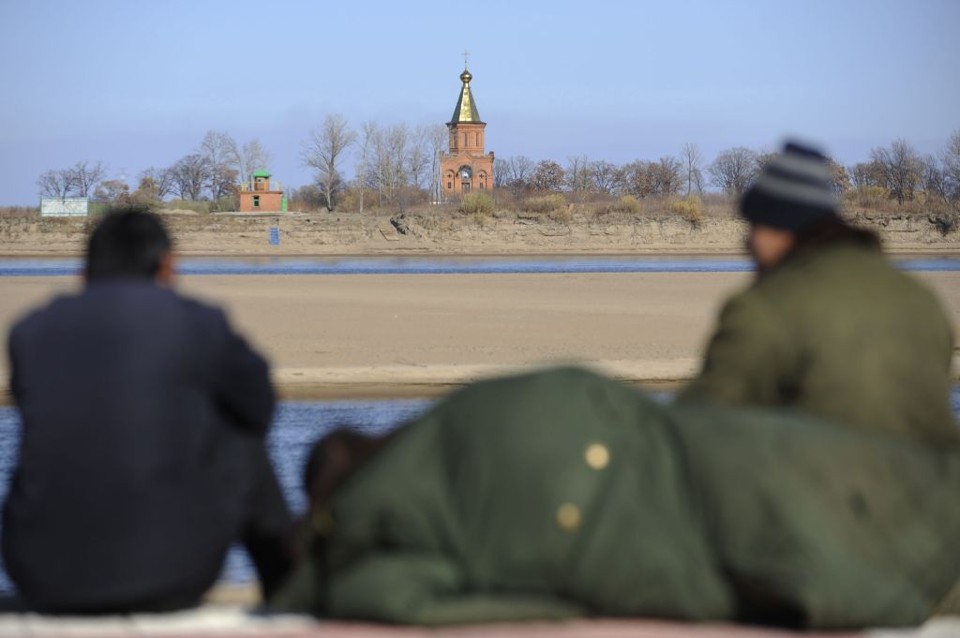 Chineses conversam próximos da fronteira leste entre a China e Rússia: devolução à China das ilhas de Yinlong e metade de Heixiazi | Stringer / Reuters