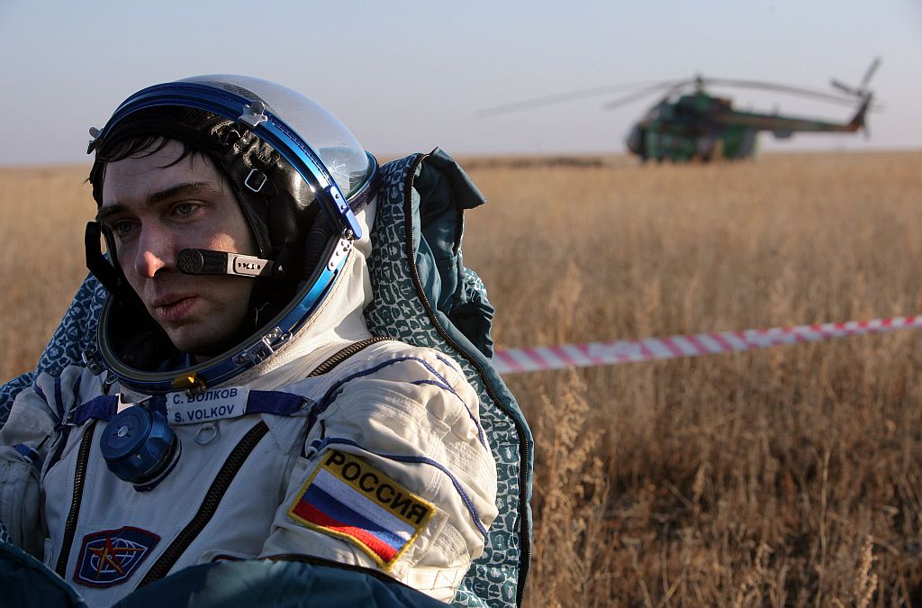 Cosmonauta russo Sergei Volkov descansa após aterrissagem da nave Soyuz, próximo de Arkalyk, no Casaquistão | Dmitry Kostyukov / Reuters