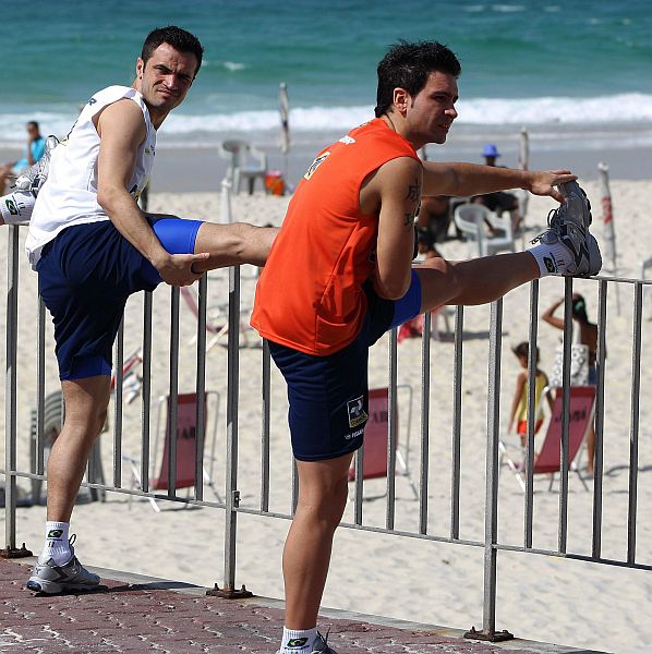 Falcão (à esq.), artilheiro do Brasil no Mundial, alonga durante treinamento na praia. | Alexandre Cassiano/Agência Globo