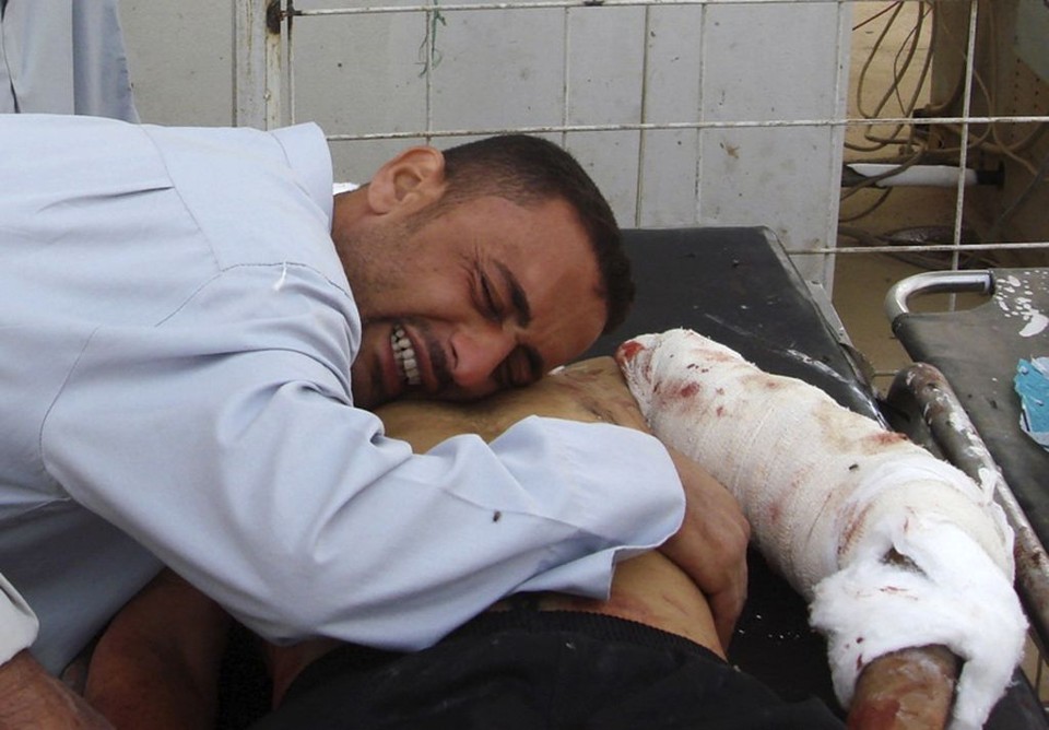 Homem chora sobre o corpo do irmão, vitíma de tiroteio em um microônibus: vítimas sunitas se dirigiam a Baquba para comemorar o Eid al-Fitr | Helmiy al-Azawi / Reuters