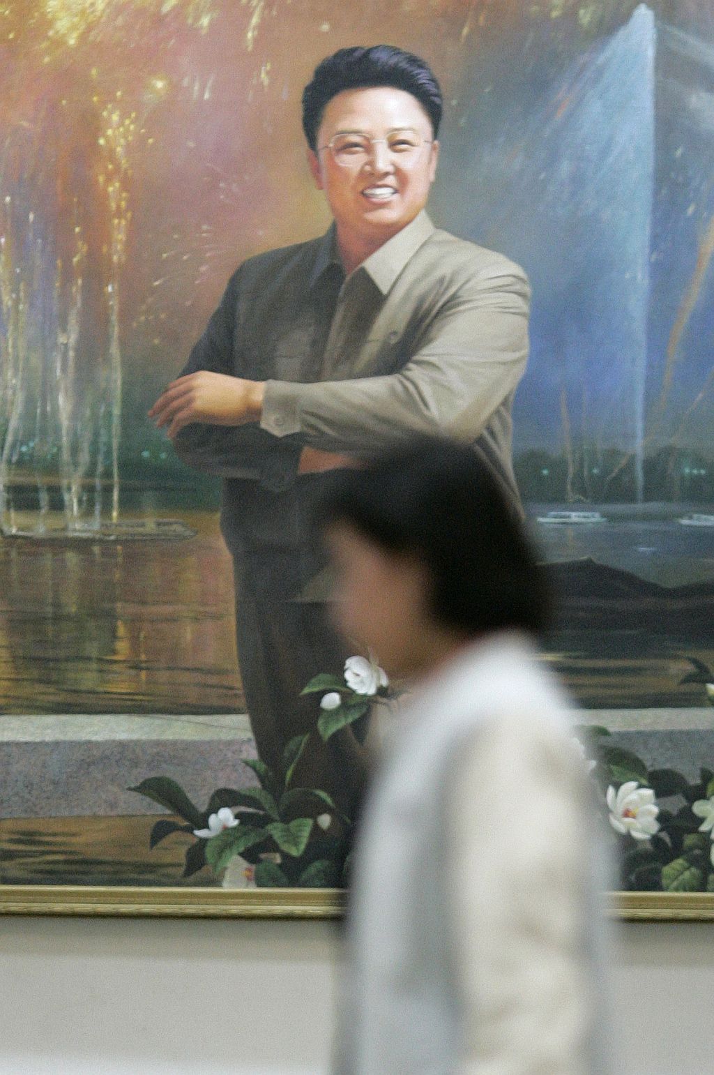 Mulher passa próximo de retrato de Kim Jong-il, em Pyongyang: especulações sobre seu estado de saúde | Jo Yong-Hak / Reuters