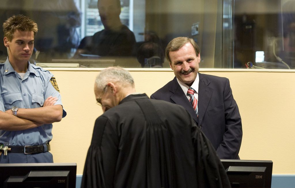 Martic (dir.) não demonstrou nenhuma emoção e saiu até mesmo bem humorado após Câmara rejeitar as apelações e confirmar pena de 35 anos de prisão | Toussaint Kluiters / Reuters