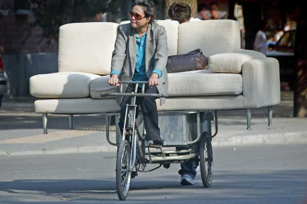Mulher carrega sofá de três lugares num triciclo | Reuters