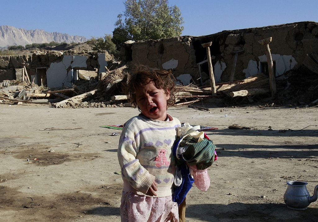 Menina chora próximo a casa destruída, em Ziarat. Soldados paquistaneses tentam ajudar dezenas de milhares de sobreviventes nas montanhas remotas | Athar Hussain / Reuters