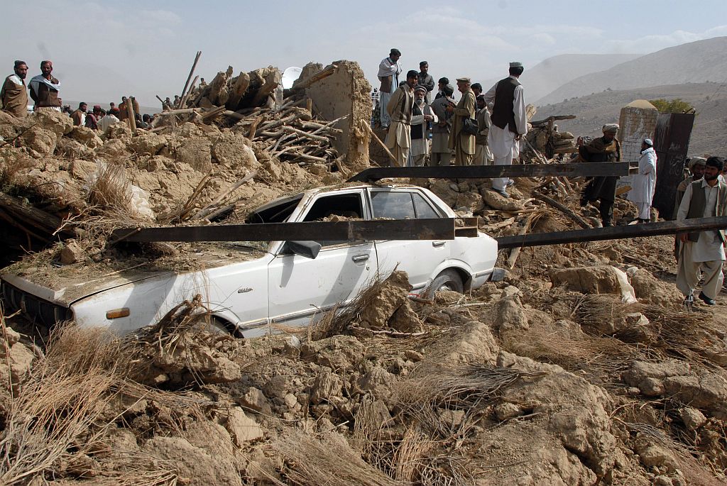 Paquistaneses observam carro atingido por escombros: construções destruídas eram frágeis | Banaras Khan/AFP