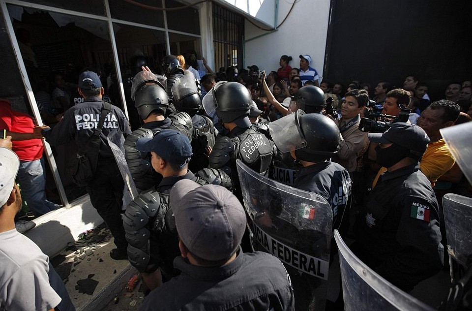 Policiais fortemente armados contêm familiares dos detentos que tentaram invadir a penitenciária, após briga de guangues que resultou em mortes e feridos | Tomas Bravo / Reuters