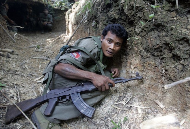 Soldado cambojano agacha-se para não ser alvejado por tiros, durante disputa pelo templo de Preah Vihear | Chor Sokunthea / Reuters